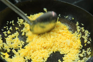 大火加熱炒鍋，再入油，燒到四至五成熱時倒入雞蛋液，在未凝結(jié)之前，加米飯煸炒，不停翻炒并用鍋鏟將成塊的米飯碾開、撥散。