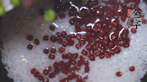 將炒好的食材和大米、紅豆一起放進(jìn)電飯鍋煮。