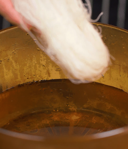 選用鮮嫩蠶豆，剝?nèi)ネ鈿ち粝露姑紫磧?，掰開成兩瓣。