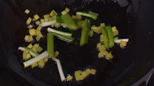 鍋中熱油，依次下姜粒、蔥段、蘆筍炒香。
