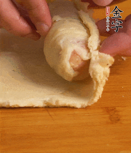 吐司卷起香腸，吐司尾端涂抹少許全蛋液，卷好的吐司表面蘸上蛋液，在裹上一層面包糠，送入預(yù)熱好的烤箱中。