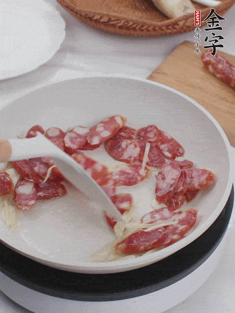 油溫3成熱時(shí)，下姜絲、蒜片、香腸炒出油脂。