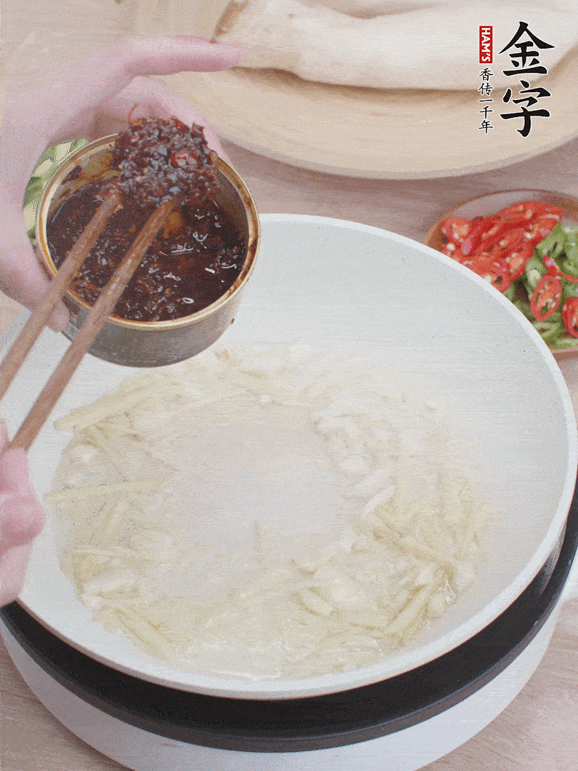 起鍋熱油，姜蒜、金字火腿干貝醬煸香。