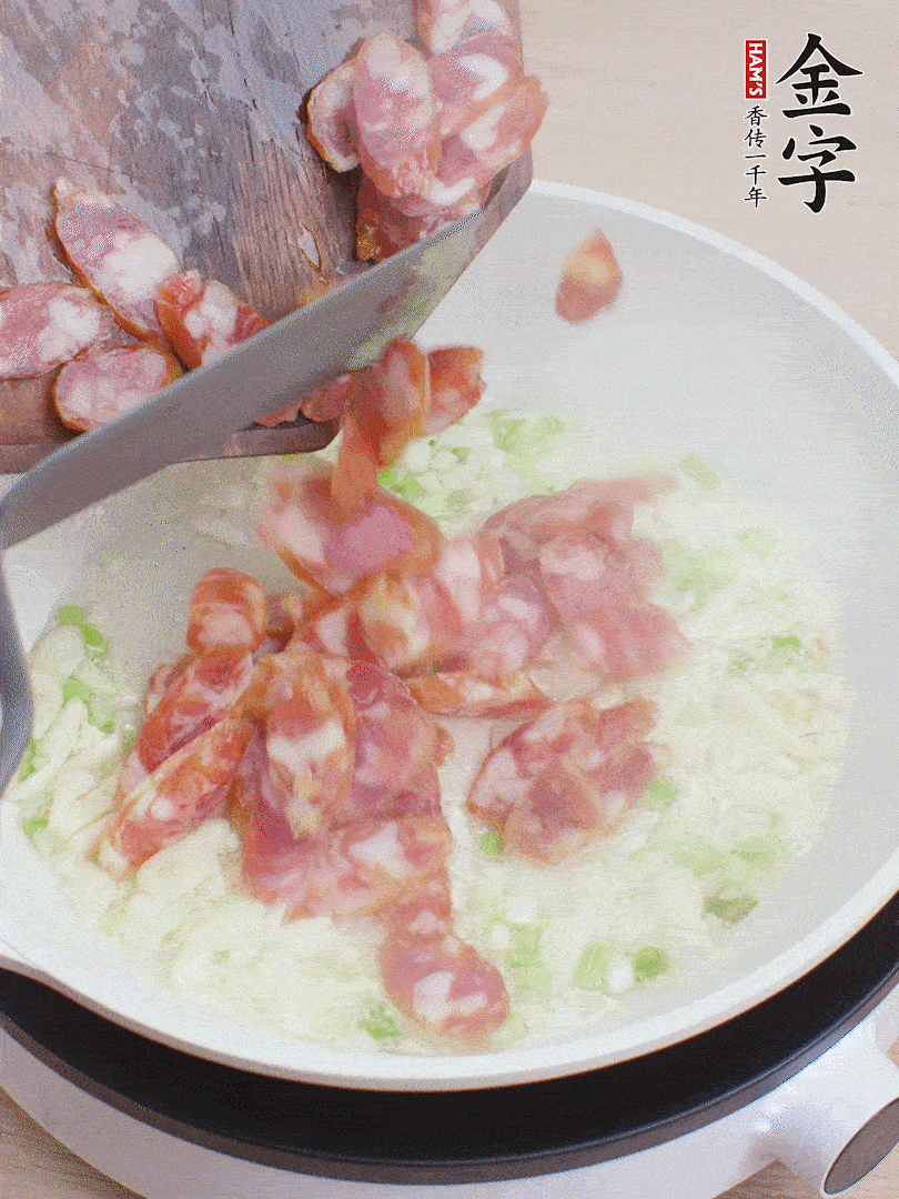 油5成熱，蒜末、蔥白爆香，下香腸炒出香味。