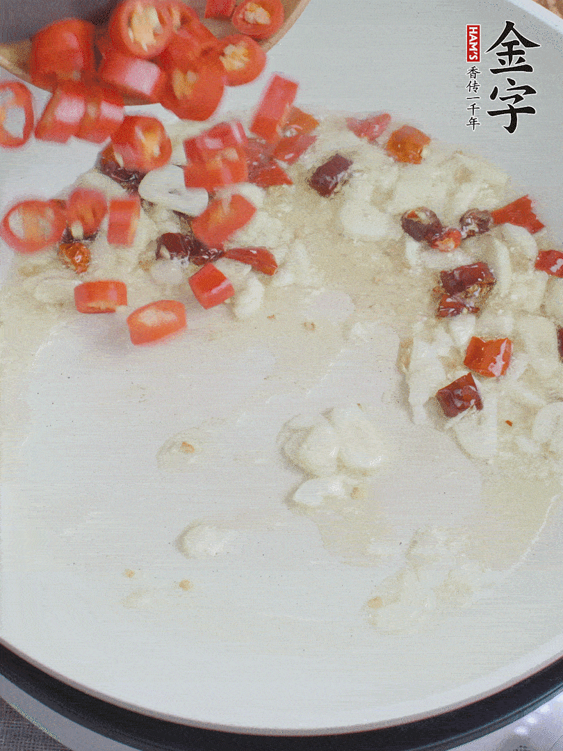 油6成熱，下蒜末、干紅辣椒煸炒，出香味后再放美人椒、香腸。