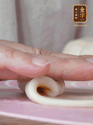 做面劑 油皮按扁，中間包入一個(gè)油酥，邊緣收緊捏死。包好的面劑按扁，用搟面杖搟壓成橢圓形。從底部向上卷成筒狀，用保鮮膜蓋好松弛15分鐘，再把筒狀縱向搟壓成長條狀。再卷一次，松弛20分鐘