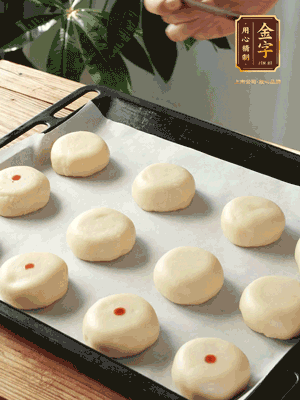 收口向下放在案板上，輕輕將月餅坯按扁，用筷子點(diǎn)紅點(diǎn)做裝飾