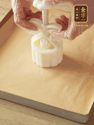 取一個面團，捏扁，中間厚，四周薄。虎口往上推，直到收口，把餅胚放入模具里，壓2-3下