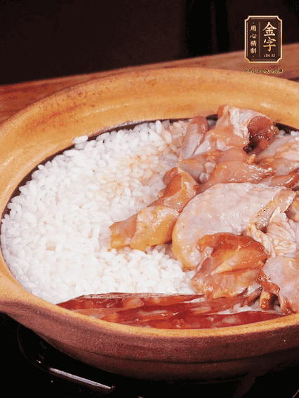 煮到椰子水微微收干轉(zhuǎn)小火，快速均勻鋪上雞肉、金字香腸