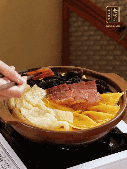 砂鍋底部鋪上娃娃菜，依次擺上肉皮、蛋餃、黑木耳、火腿